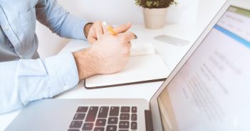 person writing on white notebook