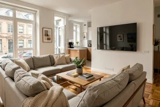 Salon meublé moderne avec équipements facultatifs séduisants pour les locataires : canapé en lin, télévision murale et machine à café dans un appartement contemporain